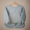 Picture of mushie Long Sleeve Baby Bib | Mess Free & Waterproof Fabric for Toddlers | Adjustable Fit for Ages 6-24 Months (Roman Green)