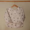 Picture of mushie Long Sleeve Baby Bib | Mess Free & Waterproof Fabric for Toddlers | Adjustable Fit for Ages 6-24 Months (Whales)